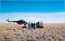  ?? COURTESY RUSSIAN DEFENSE MINISTRY PRESS SERVICE THE ASSOCIATED PRESS ?? The rescue team gather next to the Soyuz MS-10 space capsule after it made an emergency landing in a field.