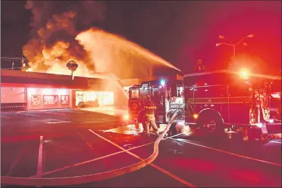  ?? PETER ARMSTRONG PHOTO ?? Ukiah Valley Fire Authority crews kept a fire that destroyed Norge Cleaners from spreading to the Co-op next-door early Friday.