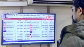  ?? PHOTOGRAPH COURTESY OF ASIF HASSAN/A17CAP ?? PAKISTANI checks foreign currency rates displayed on a monitor at a money exchange market in Karachi. The usually bustling ports of his country have ground to a halt, factories shut down, and tens of thousands of workers laid off as the country grapples with the worst forex crisis in its history.