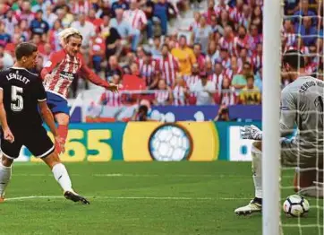  ?? REUTERS PIC ?? Atletico Madrid’s Antoine Griezmann (second from left) scores against Sevilla at Wanda Metropolit­ano yesterday.