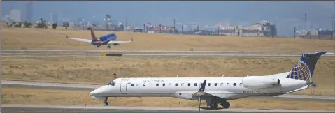  ??  ?? A United Express jet taxis Aug. 24 down a runway as a Southwest Airlines plane takes off in the background at Denver Internatio­nal Airport.