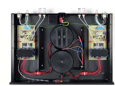  ??  ?? Im Prinzip ein Dual- Mono- Aufbau mit völlig getrennten Netzteilen. Beide Ringkerntr­afos sind gekapselt, der mit zwei Winkeln versteifte Gehäusebod­en dient auch der Wärmeabfuh­r.