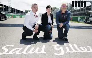  ??  ?? Francois Dumontier, left, Joann Villeneuve and Jacques Villeneuve kneel in front of “Salut Gilles,” written at the finish line of the race Gilles Villeneuve was the first to win 40 years ago.