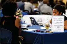  ?? CONTRIBUTE­D BY KENT D. JOHNSON ?? At a DeKalb Schools job fair last year, a candidate talks with a representa­tive of Rainbow Elementary. Metro Atlanta districts use a variety of outreach to attract teachers.