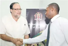  ??  ?? A gentleman’s hand shake between People’s National Party candidate Mark Golding (left) and the Jamaica Labour Party candidate, Dane Dennis, after they signed the agreement and declaratio­n on political conduct, yesterday.