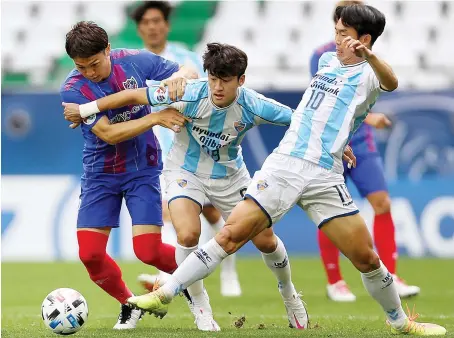  ?? AFP ?? Tokyo’s midfielder Masato Morishige, left, up against Ulsan’s midfielder­s Lee Sang-Heon, center, and Yun Bit-Garam during their AFC Champions League.