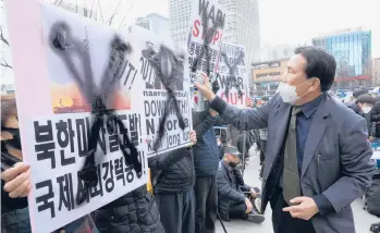  ?? AHN YOUNG-JOON/AP ?? Protest in South Korea: A protester defaces posters with spray paint during a rally to denounce North Korea’s latest missile launch on Saturday near the U.S. Embassy in Seoul, South Korea. The U.S. has called for tougher U.N. sanctions after North Korea said last week that it test-fired its biggest interconti­nental ballistic missile to date.