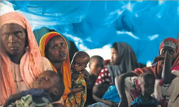  ?? DAI KUROKAWA / EFE ?? Un grupo de mujeres somalíes con sus hijos en el campo de refugiados de Ifo, uno de los tres que forman Dadaab