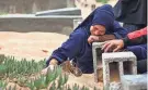  ?? AFP VIA GETTY IMAGES ?? A woman cries over a grave Wednesday at the start of the Eid al-Fitr festival, marking the end of the Muslim holy month of Ramadan, at a cemetery in Rafah in the southern Gaza Strip.