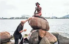  ?? IDA MARIE ODGAARD, EUROPEAN PRESSPHOTO AGENCY ?? A worker cleans the Little Mermaid statue Tuesday in Copenhagen, a day after the iconic statue at the harbor in the Danish capital was doused with red paint in what appears to be an anti-whaling protest, according to police and local media.