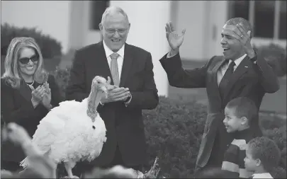  ??  ?? President Barack Obama with his nephews Aaron and Austin Robinson, and National Turkey Federation Chairman John Reicks, pardons Tot the turkey on Wednesday.