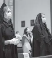  ?? PEDRO PORTAL El Nuevo Herald ?? Catholic parishione­rs attend a Mass at St. Michael the Archangel Catholic Church, wearing masks and socially distanced in the pews.