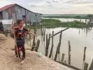  ?? ?? Prak Sophea walks along the shore of lake Boeng Tamok, which has been her home for more than 20 years. Photograph: Fiona Kelliher