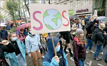  ??  ?? Environmen­tal activists wearing face masks to help protect against the spread of the coronaviru­s stage a rally to mark the Global Day of Climate Action on Friday in Vienna, Austria. (AP Photo/Ronald Zak)