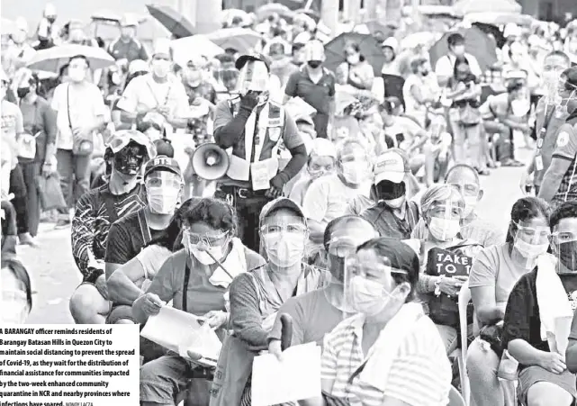  ?? NONOY LACZA ?? A barangay officer reminds residents of barangay batasan Hills in Quezon City to maintain social distancing to prevent the spread of Covid-19, as they wait for the distributi­on of financial assistance for communitie­s impacted by the two-week enhanced community quarantine in ncr and nearby provinces where infections have soared.