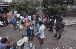  ??  ?? SERVICIO. Miembros de la Guardia Nacional vigilan la recolecció­n de agua, en la autopista Francisco Fajardo, en Caracas