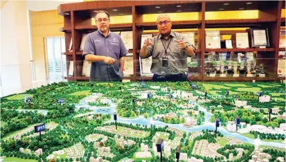  ??  ?? BELUM 100 PERSEN: Presiden Perbadanan Putrajaya Dr Aminuddin Bin Hassim (kanan) dan Amran menunjukka­n maket Putrajaya. Sekitar 40 persen wilayah tersebut adalah lahan terbuka hijau.