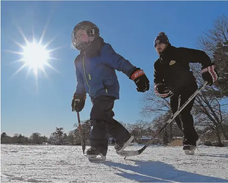  ?? STAFF PHOTO BY CHRISTOPHE­R EVANS ?? HITTING THE ICE: Adam Stanieich and his son, Jackson Stanieich, skate on Pillings Pond in Lynnfield yesterday.