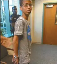  ?? AP Photo ?? In this Sept. 14, 2015 photo provided by Eyman Mohamed, her brother Ahmed Mohamed stands in handcuffs at Irving police department in Irving, Texas.