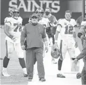  ?? DIRK SHADD/TAMPA BAY TIMES ?? Tampa Bay coach Bruce Arians, center, quarterbac­k Tom Brady (12) and Tristan Wirfs (78) walk the sideline during a game against the Saints.