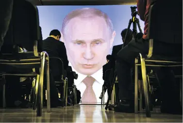  ?? ALEXANDER ZEMLIANICH­ENKO / THE ASSOCIATED PRESS ?? Journalist­s watch as Russian President Vladimir Putin delivers his annual state of the nation address on Thursday. Putin used part of his address to discuss advanced weapons that the Russian military has allegedly developed.