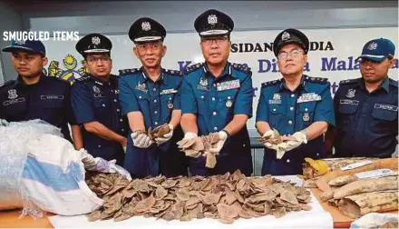  ?? BERNAMA PIC ?? Customs assistant director-general (enforcemen­t) Datuk Mohd Pudzi Man (third from right) holding the seized pangolin scales at Kompleks Kastam Kargo at Kuala Lumpur Internatio­nal Airport yesterday.