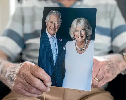  ?? ?? Wellington centenaria­n Alan Bruce displays the card for his 100th birthday last week which was signed by both King Charles III and the queen consort Camilla.