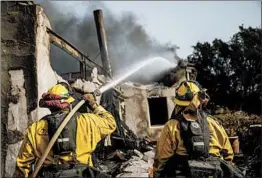  ?? MARCUS YAM/LOS ANGELES TIMES ?? A firefighte­r puts out the last of the flames Sunday at a home in Montecito, Calif.