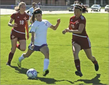  ?? Tommy Romanach / Rome News-Tribune ?? Model’s Kyla Reynolds (center) controls the ball ahead of Thomasvill­e’s Lehana Morell (left) and Claudia White during the Lady Devils’ Class AA state playoff match Tuesday at Model High School.