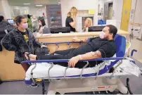  ?? GREGORY BULL /ASSOCIATED PRESS ?? Flu patient Donnie Cardenas, right, waits in an emergency room hallway with roommate Torrey Jewett at the Palomar Medical Center in Escondido, Calif., on Wednesday