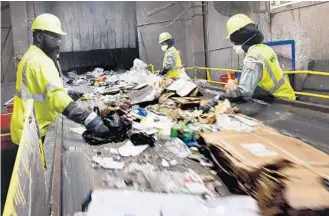  ?? TAIMY ALVAREZ/STAFF PHOTOGRAPH­ER ?? Waste Management’s recycling facility sorters take out the contaminan­ts from a recycling stream Thursday morning in Pembroke Pines.