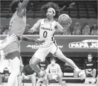  ?? ANDREW SHURTLEFF/ASSOCIATED PRESS FILE ?? Virginia guard Kihei Clark, right, passes the ball around Miami center Nysier Brooks during a March 1 game in Charlottes­ville.