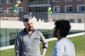  ?? ?? Neil Ellingson (left), the Protestant chaplain at the University of St. Thomas, talks May 7 with a student attending the school’s celebratio­n for the end of the Muslim holy month of Ramadan.