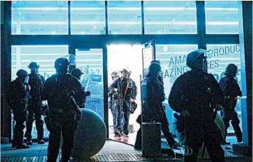  ?? NOAH BERGER/AP ?? Police officers leave a vandalized store in Emeryville, California. “There definitely was some organizati­on,” the mayor said.