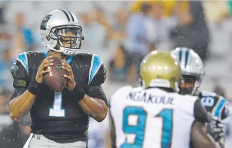  ??  ?? Panthers quarterbac­k Cam Newton looks for a receiver during his team’s preseason game Thursday night against Jacksonvil­le. Newton led a touchdown drive, going 2-for-2 with a TD pass, before taking a seat the rest of the game.