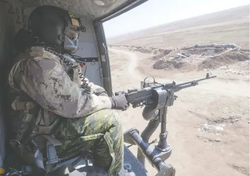  ?? RYAN REMIORZ / THE CANADIAN PRESS FILES ?? A Canadian Forces door gunner keeps watch as his Griffon helicopter goes on a mission in northern Iraq in 2017