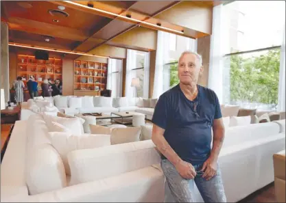  ?? The Associated Press ?? Hotelier Ian Schrager admires his latest project, the new PUBLIC hotel in New York City, from a lounge area. Located on Manhattan’s Lower East Side, the new hotel opened on Wednesday. Schrager is known for introducin­g the concept of boutique hotels and...