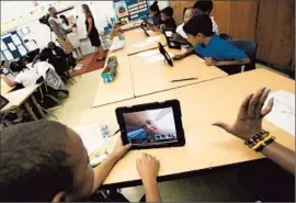  ?? Bob Chamberlin
Los Angeles Times ?? A STUDENT takes a photo of himself at Broadacres Elementary in Carson. LAUSD officials can’t explain what educationa­l problem iPads are supposed to fix.