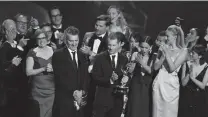  ?? Frederic J. Brown / AFP / Getty Images ?? D.B. Weiss, center, and the cast and crew of “Game of Thrones” accept the Emmy for best drama.