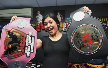  ??  ?? Hard hitter: Najihin showing off her two belts she won in MMA tournament­s at Ultimate MMA Academy in Taman Mount Austin, Johor Baru.