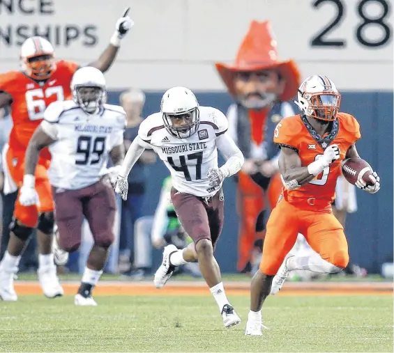  ?? [PHOTOS BY NATE BILLINGS, THE OKLAHOMAN] ?? Justice Hill (5) breaks away from the Missouri State defense Thursday for a 92-yard run — the fourth-longest in Oklahoma State history.