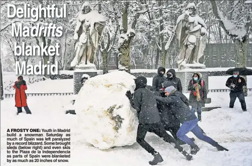  ??  ?? A FROSTY ONE: Youth in Madrid build a snowman Saturday as much of Spain was left paralyzed by a record blizzard. Some brought sleds (below right) and even skis to the Plaza de la Independen­cia as parts of Spain were blanketed by as much as 20 inches of snow.