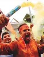  ?? Reuters, AP ?? ■
From left: A supporter of BJP holds a model of proposed Ram Temple in Ayodhya, while Hindus distribute sweets to celebrate the groundbrea­king ceremony in Hyderabad.