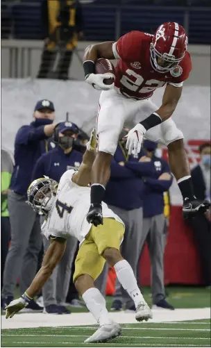  ?? MICHAEL AINSWORTH — THE ASSOCIATED PRESS ?? Alabama running back Najee Harris (22) hurdles Notre Dame cornerback Nick McCloud (4) as he carries the ball for a long gain in the first half of the Rose Bowl on Friday in Arlington, Texas.