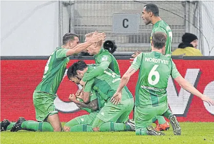  ??  ?? Borussia Moenchengl­adbach players celebrate after their team fought back for a 3-3 draw at Hoffenheim.