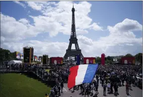  ?? FRANCOIS MORI — THE ASSOCIATED PRESS ?? A man unfurls a French flag at the Olympics fan zone at Trocadero Gardens in front of the Eiffel Tower on Aug. 8 in Paris.