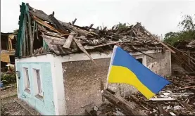  ?? Getty Images ?? A Ukrainian flag flies next to a home that was heavily damaged by a Russian rocket attack on June 15 in Dobropilli­a, Ukraine.