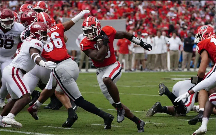  ?? John Bazemore The Associated Press ?? Georgia running back Zamir White runs for the first of his three touchdowns Saturday in the Bulldogs’ 37-0 win over Arkansas at Sanford Stadium.