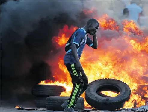  ?? BRIAN INGANGA / THE ASSOCIATED PRESS ?? Opposition supporters burn tires at a barricade in Nairobi, Kenya, Tuesday. Deadly violence continued in the African country after President Uhuru Kenyatta was sworn in for a second term, ending months of election uncertaint­y.