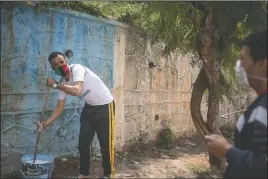  ??  ?? Volunteers prepare an area before painting in El Youssoufia, Rabat, Morocco.